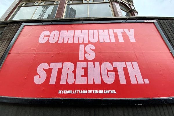 A large sign with the words "Community is strength"