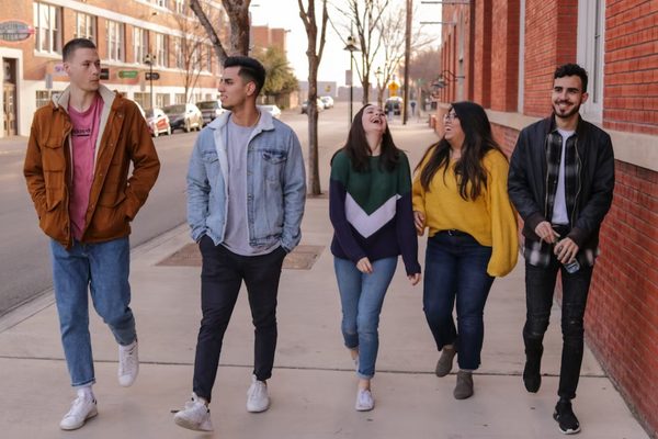 A group of five youth walking down a city street