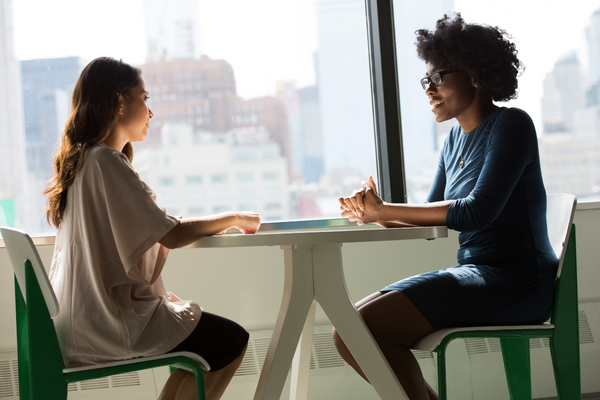 Two people sitting at a table and having a conversation