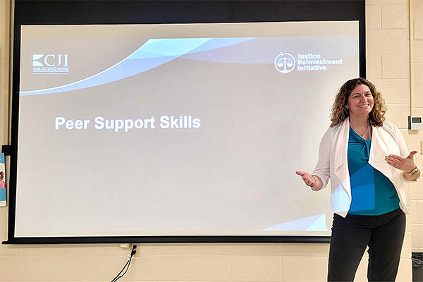 Valerie Meade standing in front of presentation screen